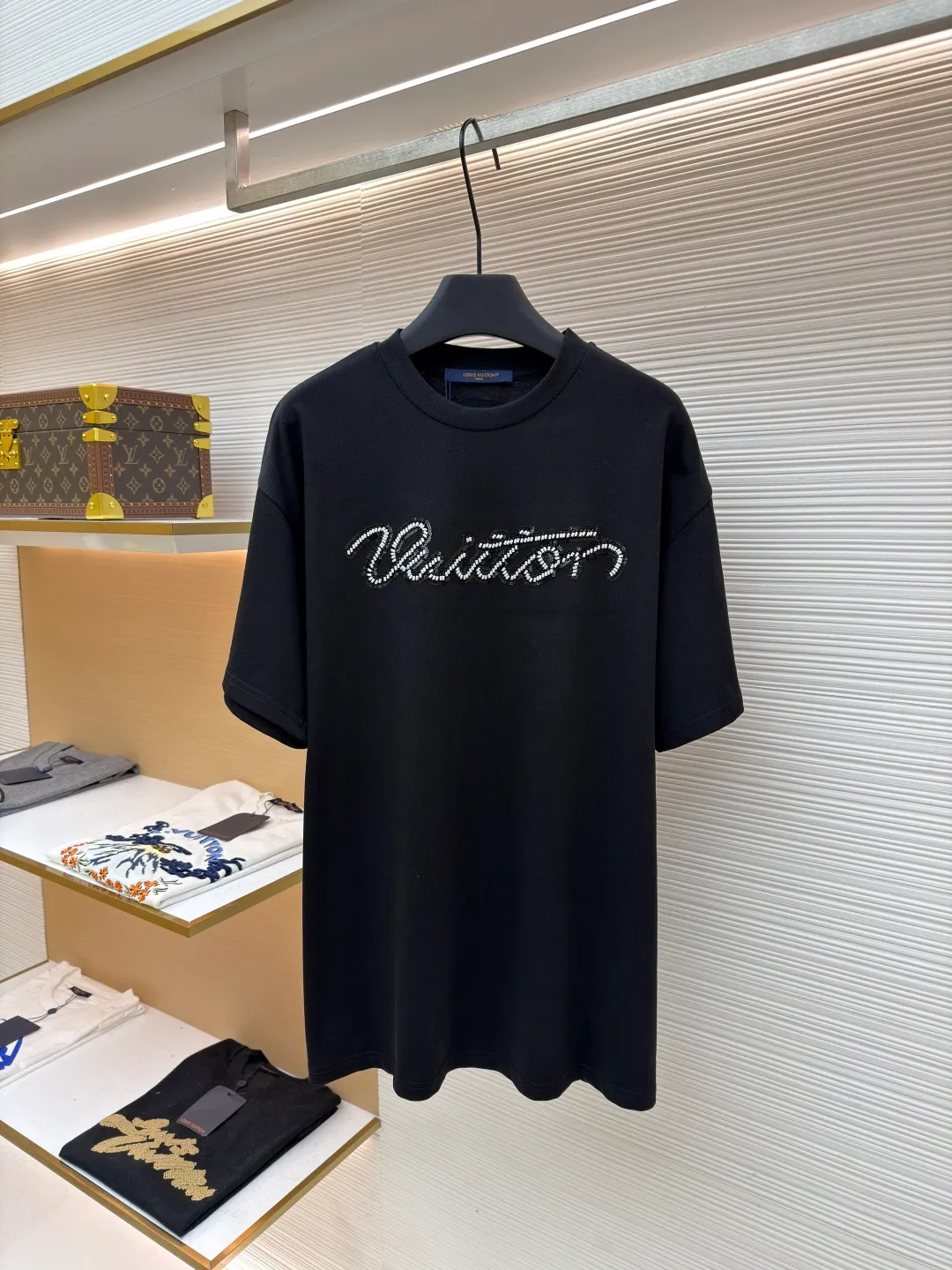 LOUIS VUITTON round neck beaded embroidered short-sleeved T-shirt ●Original version: purchased and developed by 11353 ●Item number: 1681544-A15 ●Material: cotton fabric ●Technology: beading ●Color: black ●Version: fitted version ●Weight: about 310 grams ●Size: XS-S-M-L ●Description: This black T-shirt is made of 100% High-quality cotton fabric, soft to the touch, skin-friendly and breathable. The round neck design fits the neck line and is neatly cut, presenting a classic and simple silhouette. The word "Vuitton" on the chest is the highlight of the entire work: using hand-beading technology, each tiny bead is carefully arranged by craftsmen and fixed on the fabric at precise spacing and angles, forming smooth curves and a full three-dimensional sense. This process not only gives the letters a delicate luster, but also adds to the overall texture and high-end feel. The stitching on the body is even and neat, about 12 stitches per inch, ensuring a solid structure and not easily deformed. The hem and cuffs are smooth and neat, and the edges are clean and neat, reflecting the exquisite craftsmanship of clothing. The overall style presents a low-key luxury style, which is not only suitable for daily wear, but also shows quality and taste in the details. The overall wiring is straight and delicate, the fabric is comfortable and soft, and the color is consistent without color difference. It can be matched with the same style to create a fashionable look and control various occasions. Customized accessories, complete with three standards, same style for men and women!